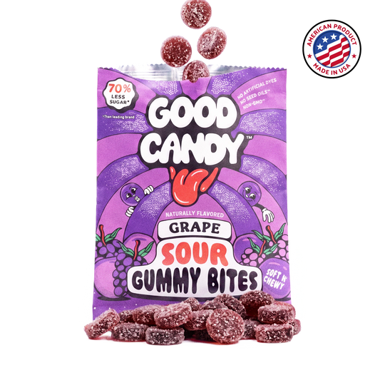 Purple sugar-coated grape gummy candy spilling out of an open Good Candy grape bag, with a Made in USA badge